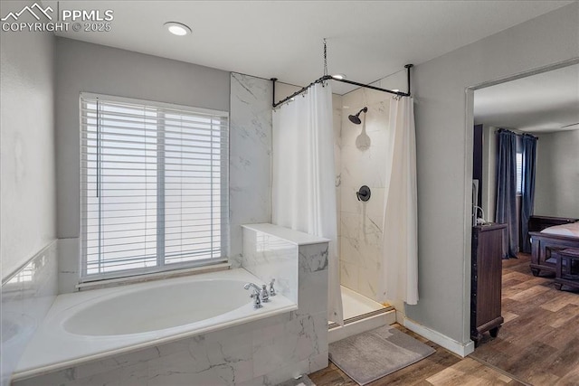 bathroom featuring hardwood / wood-style flooring, a healthy amount of sunlight, and shower with separate bathtub