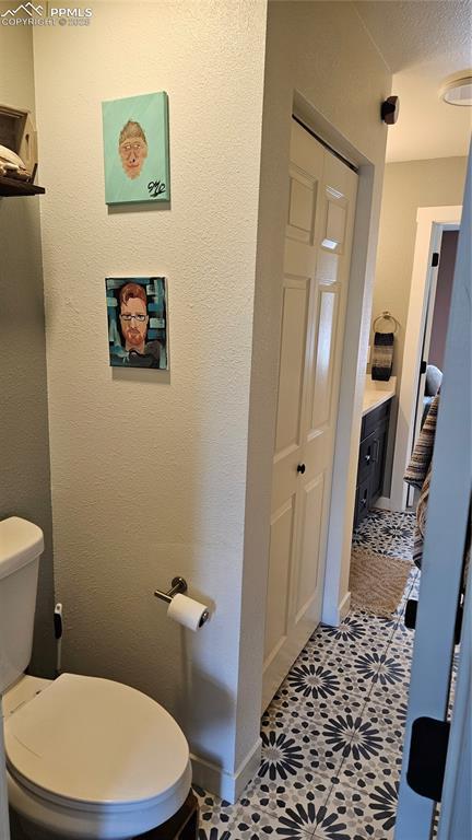 bathroom with vanity, a textured ceiling, and toilet