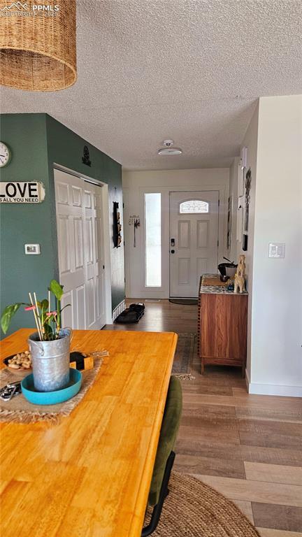 dining area featuring hardwood / wood-style flooring and a textured ceiling