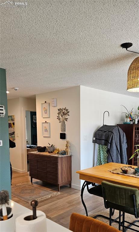 dining area with light hardwood / wood-style flooring and a textured ceiling