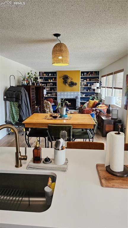 dining area featuring built in shelves, hardwood / wood-style floors, and a textured ceiling