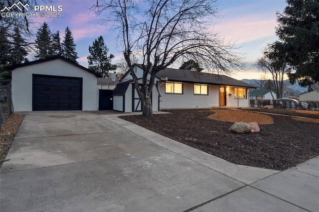 ranch-style home with an outbuilding, an attached garage, and driveway