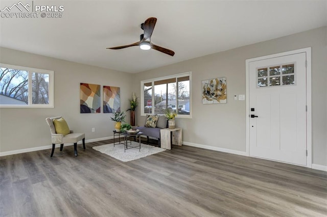 sitting room with plenty of natural light, wood finished floors, and baseboards