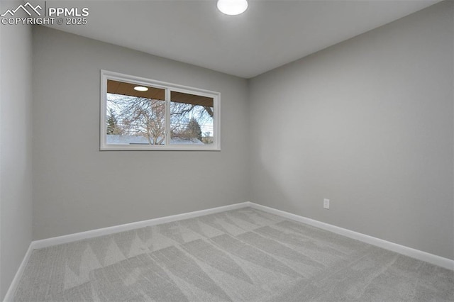 carpeted spare room featuring baseboards