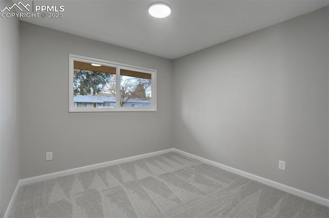 spare room featuring carpet flooring and baseboards