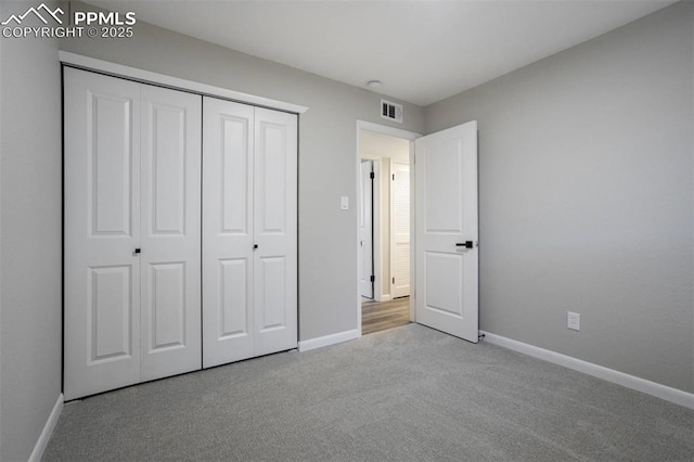 unfurnished bedroom with a closet, visible vents, baseboards, and carpet