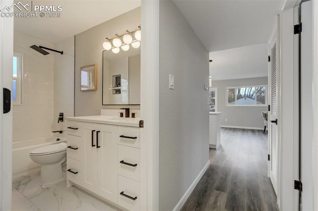 full bath with baseboards, toilet, marble finish floor, vanity, and  shower combination