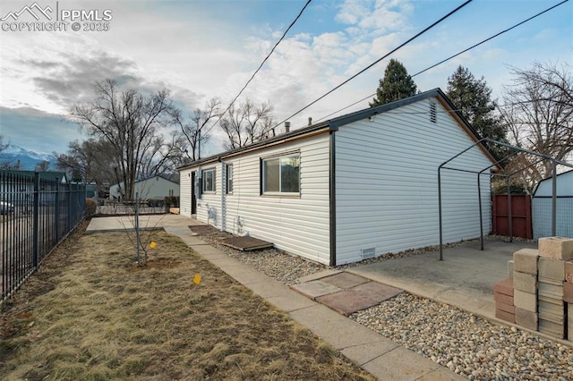 view of side of home with a storage shed, a patio, a fenced backyard, and an outdoor structure