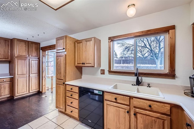 kitchen featuring black dishwasher, sink, a textured ceiling, and light tile patterned floors