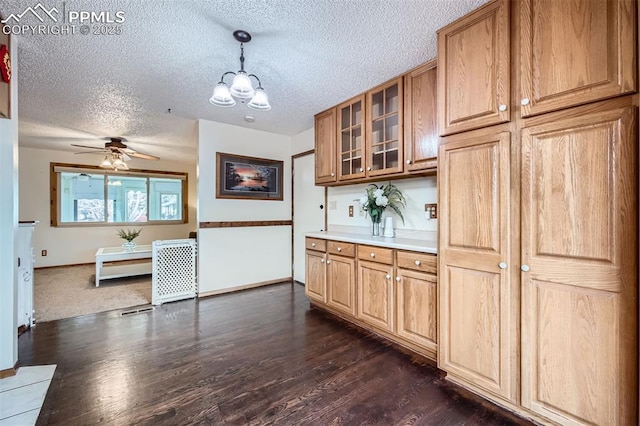 kitchen with hanging light fixtures, ceiling fan with notable chandelier, dark hardwood / wood-style floors, and a textured ceiling