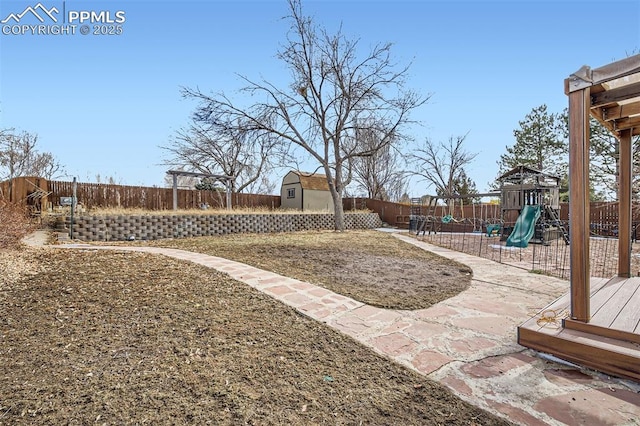 view of yard featuring a storage unit and a playground