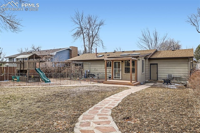 back of house with a playground