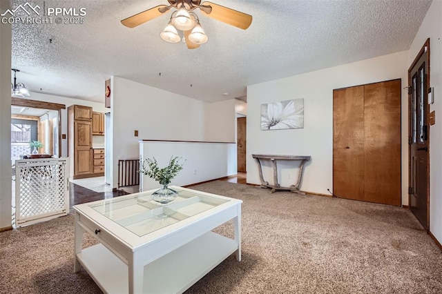 carpeted living room featuring ceiling fan and a textured ceiling