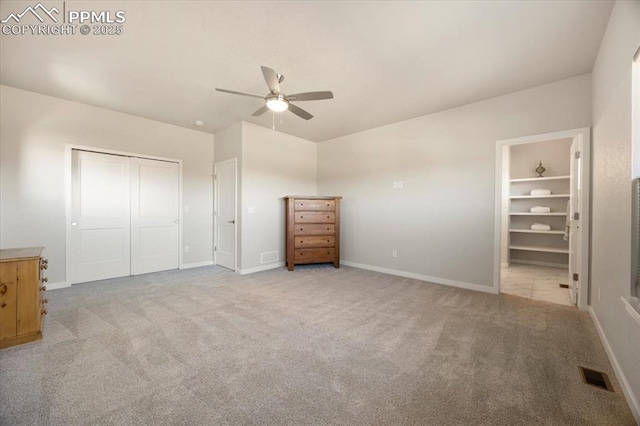 unfurnished bedroom featuring light carpet, a closet, and ceiling fan