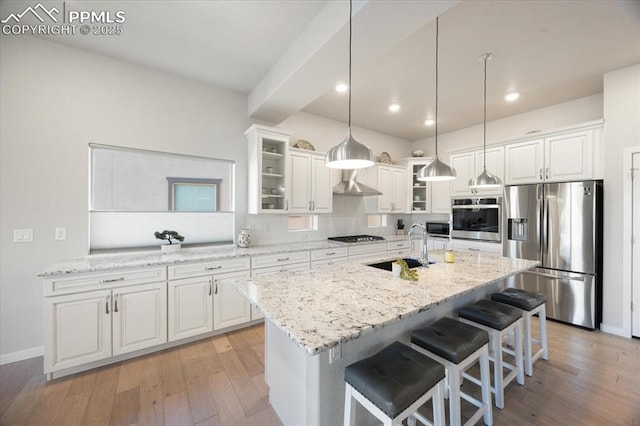 kitchen with sink, decorative light fixtures, white cabinets, and appliances with stainless steel finishes