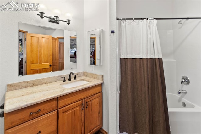 bathroom with shower / tub combo and vanity