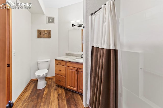 bathroom with vanity, toilet, curtained shower, and hardwood / wood-style floors