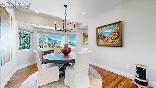 dining space with hardwood / wood-style flooring and an inviting chandelier