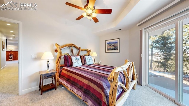 bedroom with a raised ceiling, light carpet, access to exterior, and ceiling fan