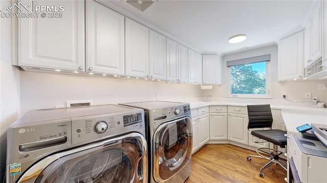 washroom with sink, light hardwood / wood-style floors, and washer and dryer