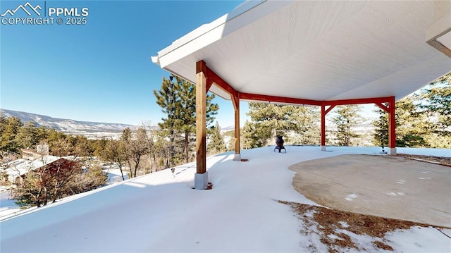 snow covered patio featuring a mountain view