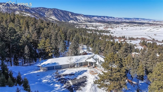 snowy aerial view with a mountain view