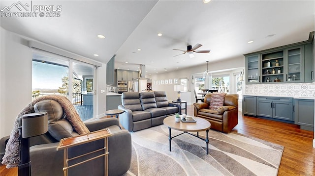 living room featuring ceiling fan and light hardwood / wood-style flooring