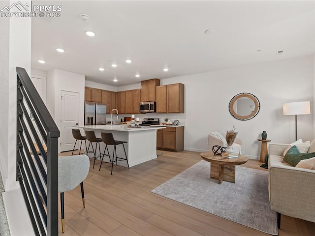 living room featuring sink and light hardwood / wood-style flooring