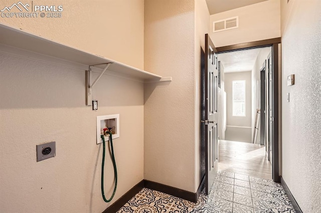 laundry area featuring washer hookup and light tile patterned flooring