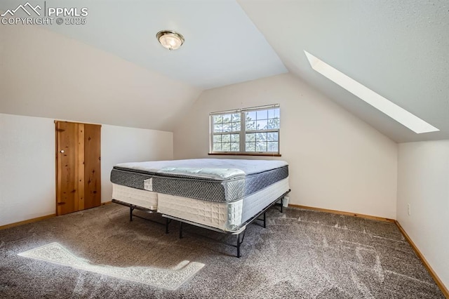 bedroom with lofted ceiling with skylight and carpet floors