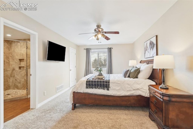 carpeted bedroom with ceiling fan and ensuite bath