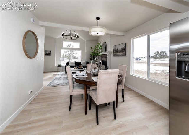 dining room featuring vaulted ceiling and light hardwood / wood-style flooring