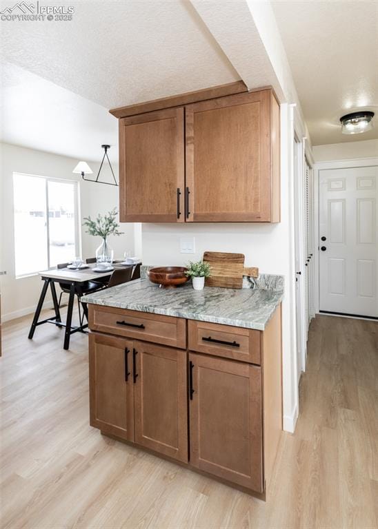 kitchen featuring light stone countertops and light hardwood / wood-style floors