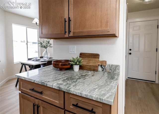 kitchen with light hardwood / wood-style flooring and light stone countertops