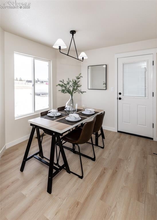 dining space with an inviting chandelier and light hardwood / wood-style floors