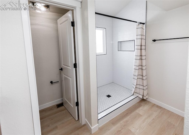 bathroom featuring wood-type flooring and walk in shower