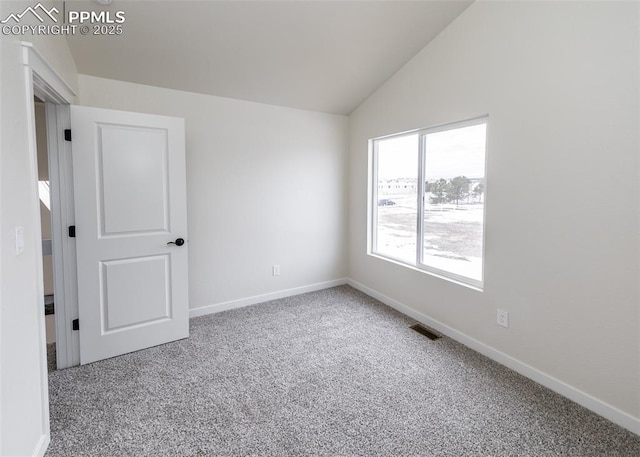 carpeted spare room with lofted ceiling