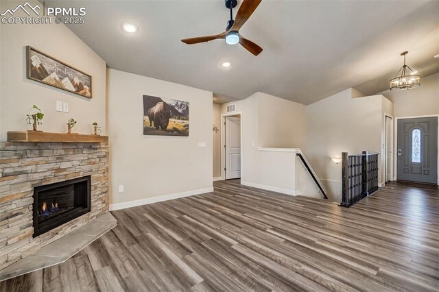 unfurnished living room with a fireplace, dark hardwood / wood-style flooring, and vaulted ceiling