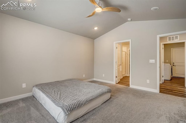 bedroom featuring ceiling fan, lofted ceiling, ensuite bath, and light carpet