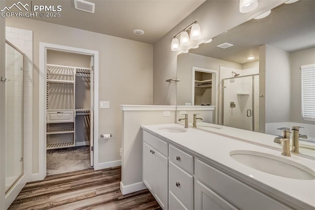 bathroom with vanity, a shower with shower door, toilet, and wood-type flooring