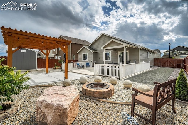 rear view of house with a storage unit, a patio area, and a fire pit