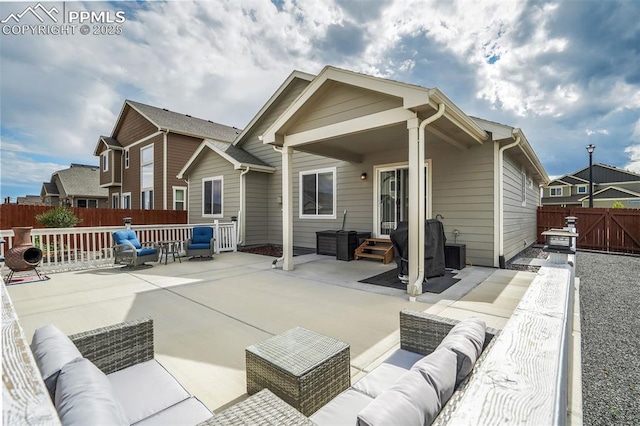 rear view of property featuring an outdoor living space and a patio area