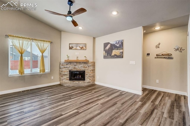 unfurnished living room featuring lofted ceiling, ceiling fan, a fireplace, and wood-type flooring