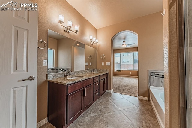 bathroom featuring ceiling fan, tile patterned floors, vanity, and a tub