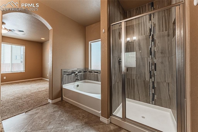 bathroom featuring separate shower and tub, tile patterned floors, and a textured ceiling