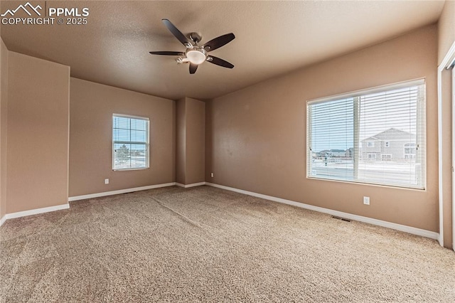 carpeted spare room featuring a textured ceiling and ceiling fan