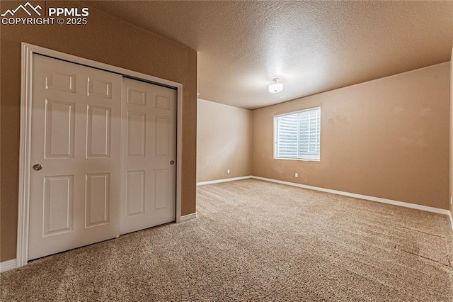 unfurnished bedroom featuring a closet, a textured ceiling, and carpet