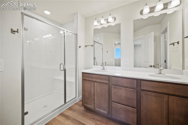 bathroom with hardwood / wood-style flooring, vanity, and an enclosed shower