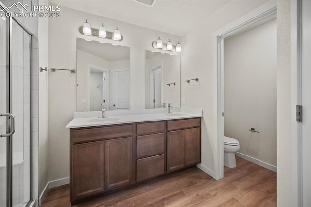 bathroom featuring wood-type flooring, toilet, and an enclosed shower