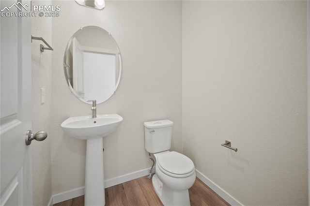 bathroom with wood-type flooring, sink, and toilet